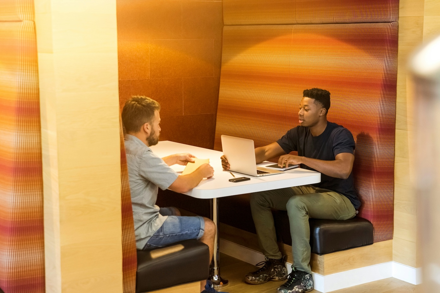 Two men meeting in a booth.
