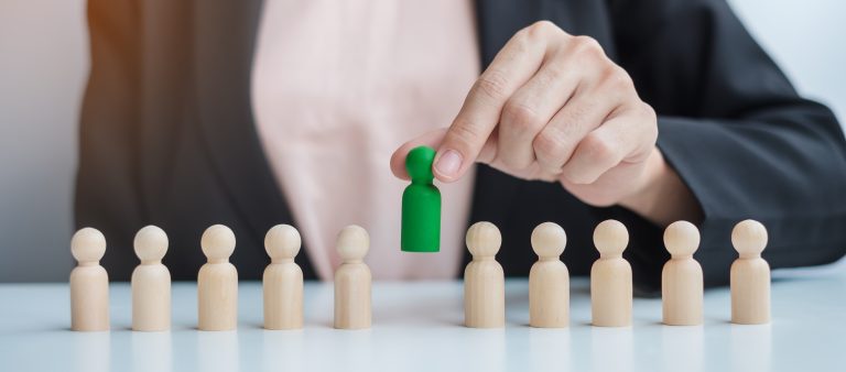 Businesswoman hand pulling managed service provider option wooden from crowd of other providers. Concepts, how to choose a managed service provider, benefits of a managed service provider