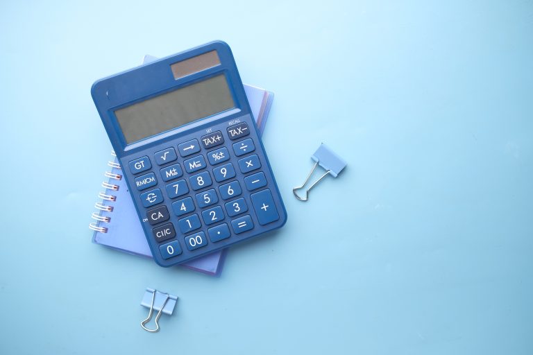 Close up of blue calculator and notepad on color background, Is Managed IT Support Worth It