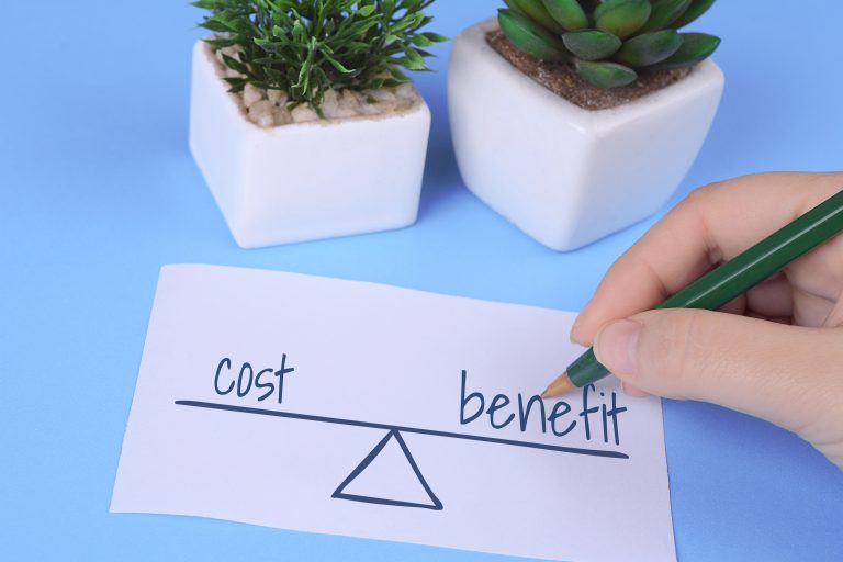 womans hand holding card with words cost vs benefit, Managed IT Cost, Managed IT Pricing